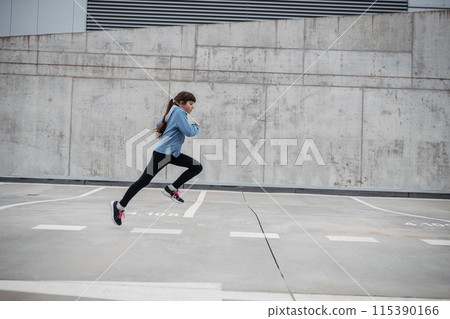 Girl in city running, doing sport. Young girl spending free time exercising, enjoying after school outdoor activity. Girl in city running, doing sport. Young girl spending free time exercising, enjoying after school outdoor activity. 115390166