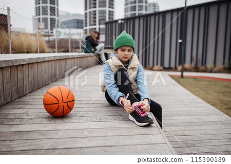 Girl in the city going to play basketball. Young girl spending free time doing sport, enjoying after schoold outdoor activity. Girl in the city going to play basketball. Young girl spending free time doing sport, enjoying after schoold outdoor activity. 115390189
