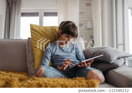 Young schoolgirl struggling with learning at home, doing homework. Learning difficulties in children 115390212