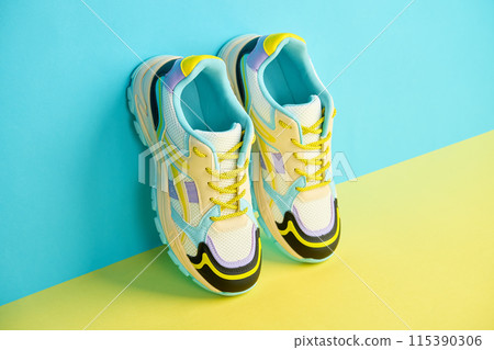 White sneakers with colored accents on bright background, Pair of fashionable sport shoes with colorful backdrop. Studio shot of shoes for shop advertisement, creative minimalist style White sneakers with colored accents on bright background, Pair of fashionable sport shoes with colorful backdrop. Studio shot of shoes for shop advertisement, creative minimalist style 115390306
