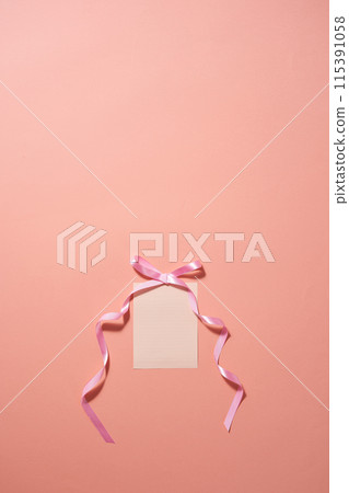 a sheet of paper tied with a pink ribbon 115391058