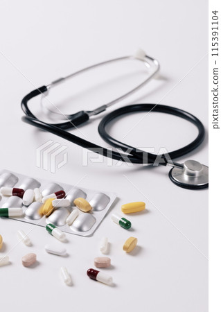 stethoscope and scattered pills 115391104