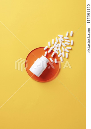 the white pills pouring out of the vat 115391120