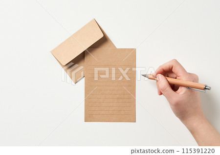 a hand to write on a paper sheet a hand to write on a paper sheet 115391220