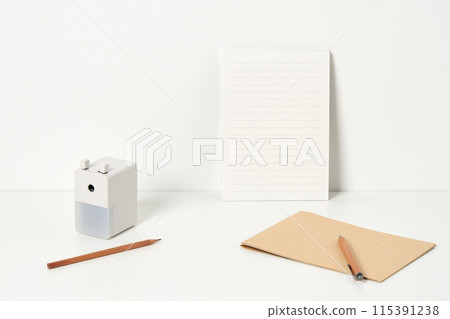 a pencil sharpener and pencil in front of a letter paper 115391238