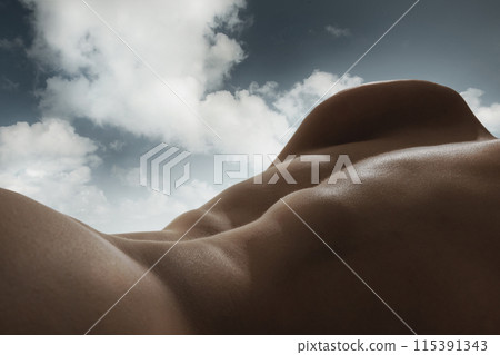Human form and the sky blend into one continuous landscape. Male relief body, back blending with natural sky background. Sense of peace and harmony 115391343