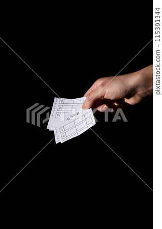 a hand holding several torn ballots a hand holding several torn ballots 115391344