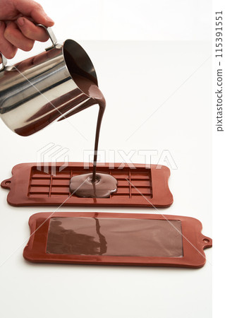 melted chocolate poured into a chocolate mold 115391551
