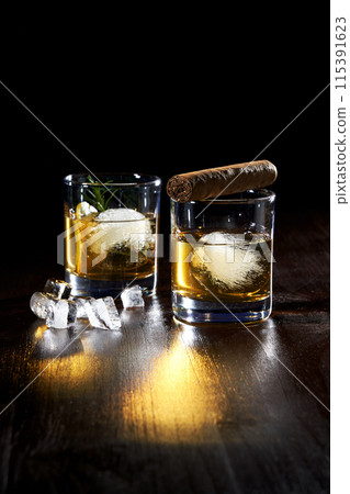 composition of two glasses of cold whiskey and cigar 115391623