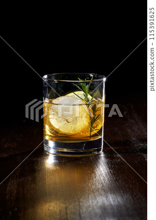 a glass of whiskey with lemon and ice a glass of whiskey with lemon and ice 115391625