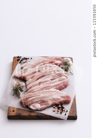 fresh pork belly piled on wooden chopping boards 115391650
