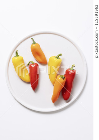 Mini paprika in various colors on a white plate 115391962