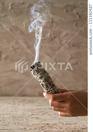 a smoky smoky hand holding a smoky stick 115392487