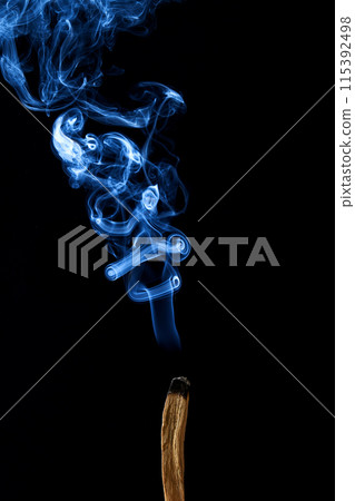 Smudge stick with smoke against a dark background 115392498
