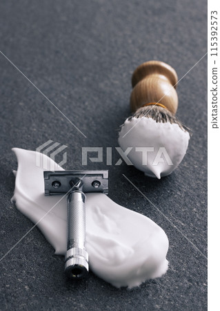 A classic razor and shaving brush with a gray tile background A classic razor and shaving brush with a gray tile background 115392573