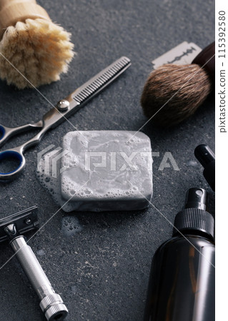 a variety of shaving supplies on a gray tile background 115392580