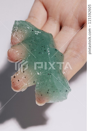 A soft, teal scrub on the palm of your hand 115392605