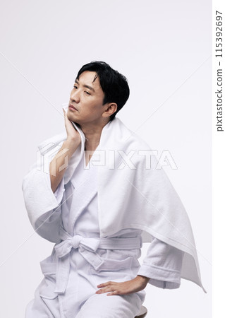 a middle aged man who wipes his face with a white towel a middle aged man who wipes his face with a white towel 115392697