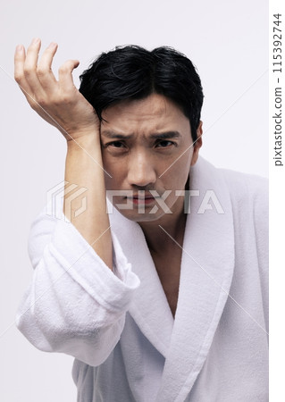 a middle aged man with his wrist on his forehead 115392744