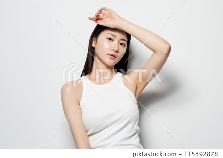 Asian woman posing with her hand on her head against a white background 115392878