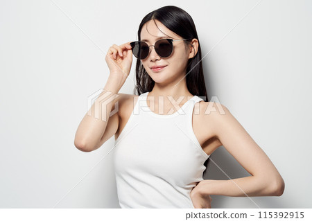 an Asian woman who wears sunglasses with one hand an Asian woman who wears sunglasses with one hand 115392915