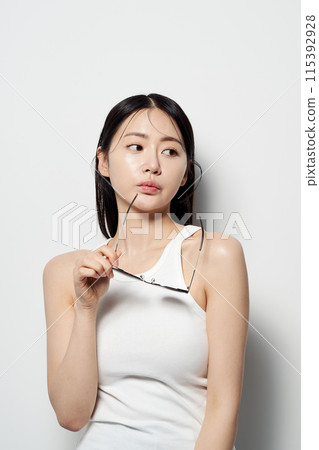 Asian Woman Stares In One Hand With Sunglasses Asian Woman Stares In One Hand With Sunglasses 115392928