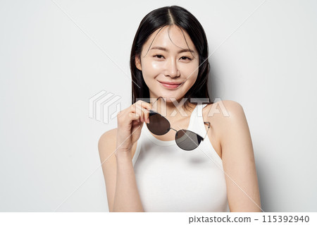 an Asian woman wearing a white sleeveless shirt and sunglasses an Asian woman wearing a white sleeveless shirt and sunglasses 115392940