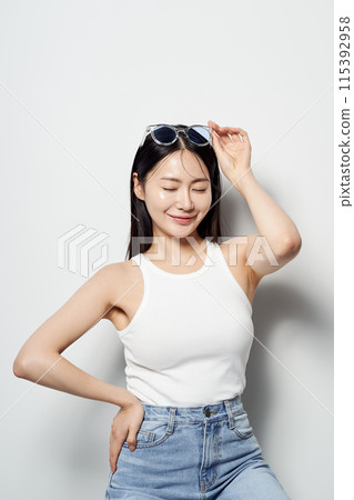 an Asian woman with sunglasses on her head and eyes gently closed 115392958