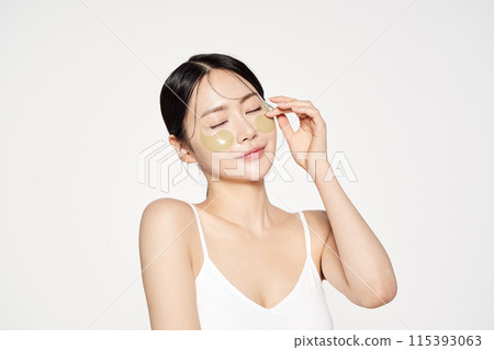 Asian woman posing with eye patches on both cheeks Asian woman posing with eye patches on both cheeks 115393063