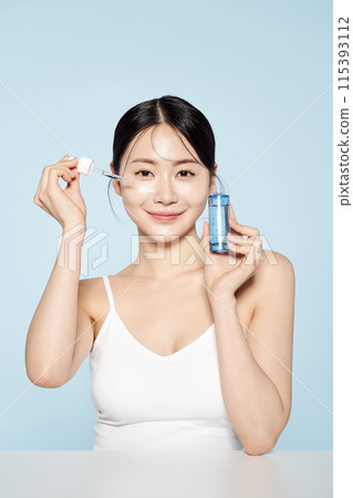 Asian woman posing with eye patches on both cheeks Asian woman posing with eye patches on both cheeks 115393112