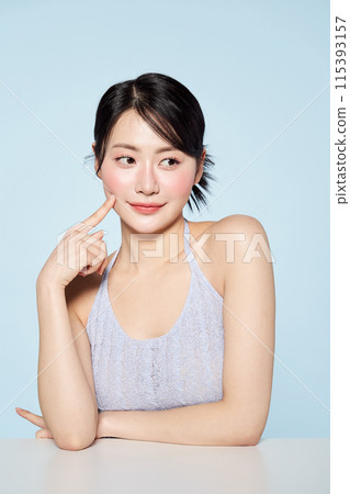 an Asian woman touching her Han Chinese cheek with her fingers an Asian woman touching her Han Chinese cheek with her fingers 115393157