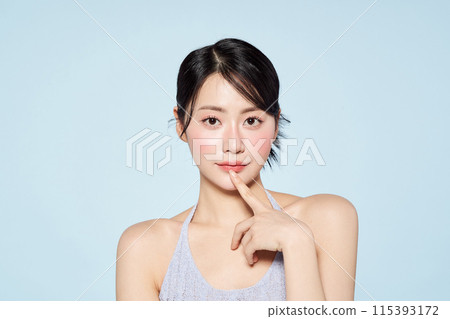 Asian woman touching her lips and staring straight ahead 115393172