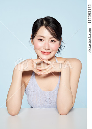 an Asian woman who smiles while clapping her hands 115393183