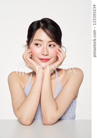 an Asian woman with her chin on her head staring at one side an Asian woman with her chin on her head staring at one side 115393234