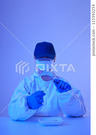CSI female researcher identifying cigarette butts evidence as magnifying at crime and incident sites with blue lights 115393254