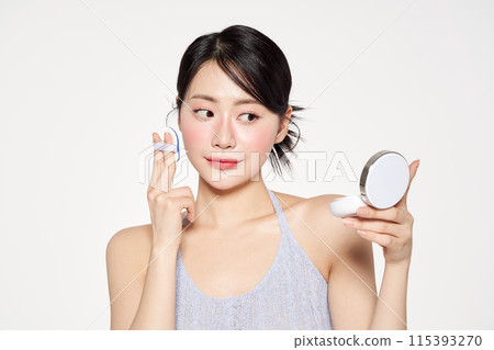 Asian Woman Putting Cushion Facts on Her Face Asian Woman Putting Cushion Facts on Her Face 115393270
