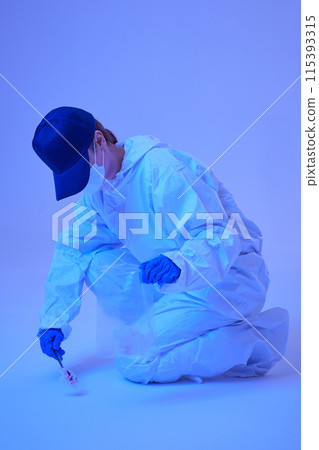 CSI female researcher sitting at crime and incident sites with blue lights collecting evidence in envelopes CSI female researcher sitting at crime and incident sites with blue lights collecting evidence in envelopes 115393315