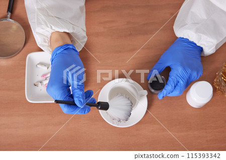 The hand of a CSI Scientific Investigation Unit researcher who is checking evidence and collecting fingerprints at crime and incident sites 115393342