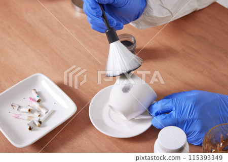 The hand of a CSI Scientific Investigation Unit researcher who is checking evidence and collecting fingerprints at crime and incident sites 115393349