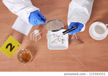 The hand of a CSI Scientific Investigation Unit researcher who identifies evidence with magnifying glasses and flashlights at crime and incident sites The hand of a CSI Scientific Investigation Unit researcher who identifies evidence with magnifying glasses and flashlights at crime and incident sites 115393351