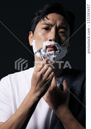 a middle aged man shaving with foam 115393457