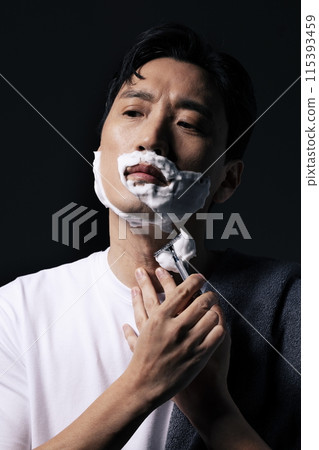 a middle aged man shaving with foam 115393459