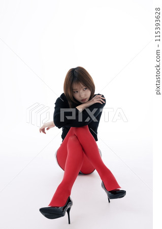 Korean Woman Sitting on the Floor in Red Leggings and Crossing Her Legs 115393628