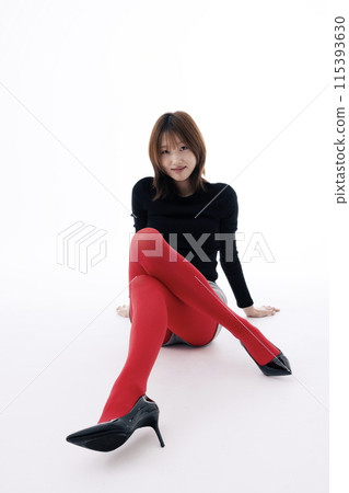 Korean Woman Sitting on the Floor in Red Leggings and Crossing Her Legs Korean Woman Sitting on the Floor in Red Leggings and Crossing Her Legs 115393630