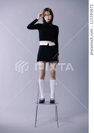 Korean Woman in Her 20s Standing on a Chair in Geekie Look 115393673
