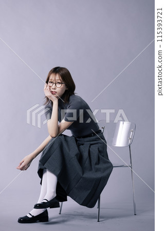 a Korean woman in her 20s who sat on a chair in a geek look style a Korean woman in her 20s who sat on a chair in a geek look style 115393721