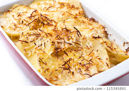 Potato gratin baked with cream and cheese isolated on white background Potato gratin baked with cream and cheese isolated on white background 115393891