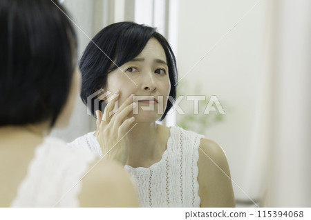 照鏡子擔心皺紋的中年女性 照鏡子擔心皺紋的中年女性 115394068