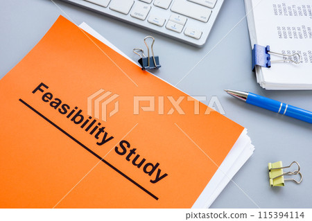 Stack of papers with feasibility study and keyboard. Stack of papers with feasibility study and keyboard. 115394114