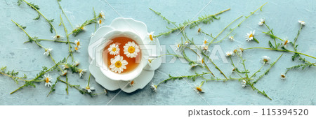 Chamomile flower tea panorama. A tea cup with infusing blossoms 115394520